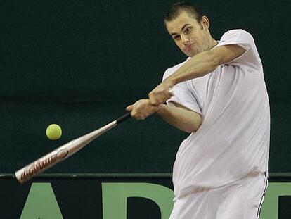 Roddick ensaya con un bate y una pelota de tenis, ayer en el estadio de La Cartuja.