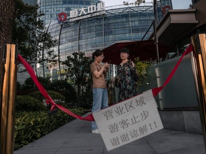 Várias pessoas diante do Centro Evergrande em Xangai, nesta terça-feira.