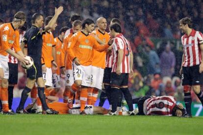 Los jugadores de Valencia y Athletic rodean a David Navarro y Fernando Llorente.