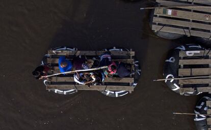 Migrantes utilizan una balsa hecha a mano para cruzar el río Suchiate, frontera natural entre México y Guatemala, en Ciudad Hidalgo (México).