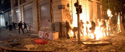 Un grupo de manifestantes lanza cócteles molotov contra los agentes de la Policía, el domingo por la noche, en las calles de Atenas.