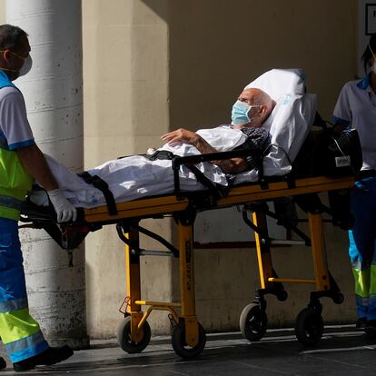 Healthcare workers wearing protective masks push a patient on a stretcher near the emergency unit at 12 de Octubre hospital, amid the outbreak of the coronavirus disease (COVID-19), in Madrid, Spain August 14, 2020. REUTERS/Juan Medina