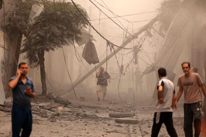 Residentes de Gaza observan los destrozos causados por los bombardeos israelíes, este lunes.