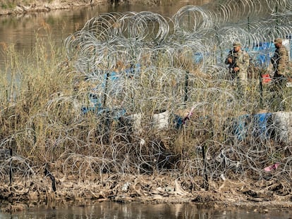 Una familia de migrantes habla con miembros de la Guardia Nacional de Estados Unidos después de cruzar el río Grande en Eagle Pass, Texas, la semana pasada.