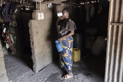 Una mujer llega a casa y bebe agua extraída del lago. Vive con su marido en el campo y tienen cuatro hijos pequeños. El 65% de la población en República Democrática del Congo vive en zonas rurales, aisladas debido a la falta de infraestructuras y carreteras. Como Ngandanjika.