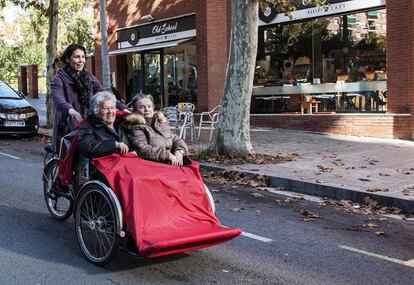 Una voluntària d'Amb Bici Sense Edat passeja dues dones grans perquè surtin de la residència i visitin els seus antics veïnats.