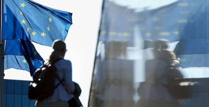 Una mujer pasa por delante de la bandera de la UE en la sede de la Comisión Europea, en Bruselas.