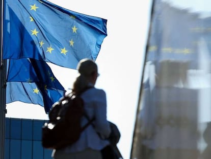 Una mujer pasa por delante de la bandera de la UE en la sede de la Comisión Europea, en Bruselas.