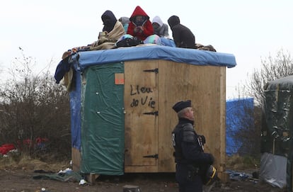 Un grupo de inmigrantes intenta evitar que les desalojen del campo de Calais, Francia.