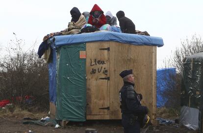 Un grupo de inmigrantes intenta evitar que les desalojen del campo de Calais, Francia.