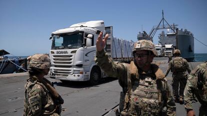 Camiones cargados con ayuda humanitaria llegan al muelle flotante Trident, en la costa de Gaza este martes.