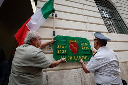 Dos hombres preparando una de las oficinas de votación de Roma para la elección de este domingo. 
