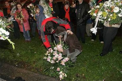 Los padres de los dos niños atropellados el martes en Basurto dejan un ramo de flores en el lugar de la tragedia.