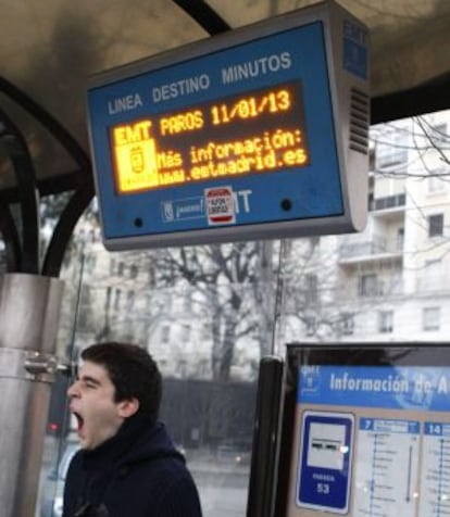 Un joven espera el autob&uacute;s en una parada del paseo de la Castellana esta ma&ntilde;ana.