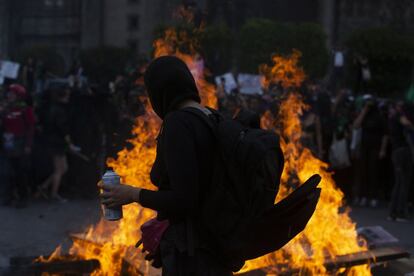 Una manifestante observa el fuego durante la manifestación.