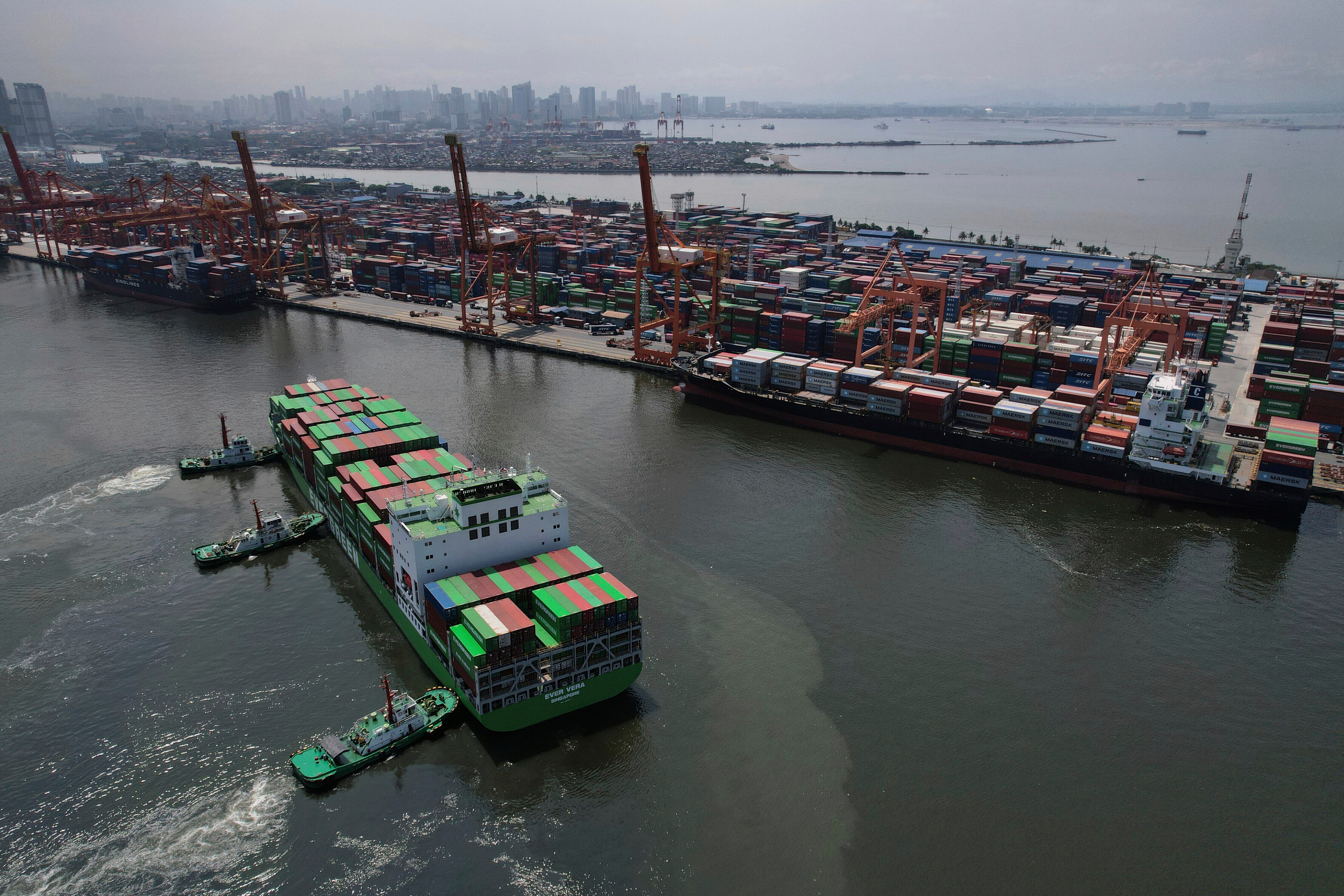 Remolcadores asisten a un buque portacontenedores en la Terminal Internacional de Contenedores de Manila.