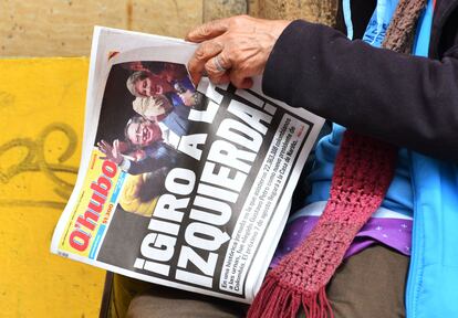 Una mujer sostiene un periódico cuya portada dice "¡Giro a la izquierda!",  al ​​día siguiente de que Gustavo Petro fuera elegido presidente de Colombia, en Bogotá, el 20 de junio de 2022.