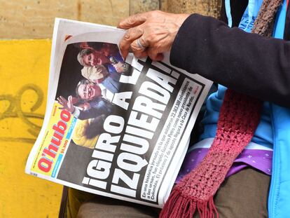 Una mujer sostiene un periódico cuya portada dice "¡Giro a la izquierda!",  al ​​día siguiente de que Gustavo Petro fuera elegido presidente de Colombia, en Bogotá, el 20 de junio de 2022.