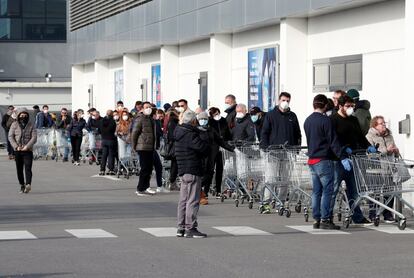 Una multitud espera su turno para comprar víveres, en el exterior de un supermercado, en la localidad italiana de Casalpusterlengo.