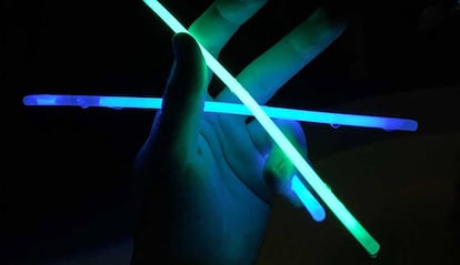 Una mano iluminada por tiras luminiscentes