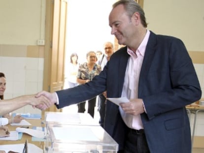 El alcalde de Castellón y candidato a la reelección, Alberto Fabra, saluda a los componentes de la mesa electoral.