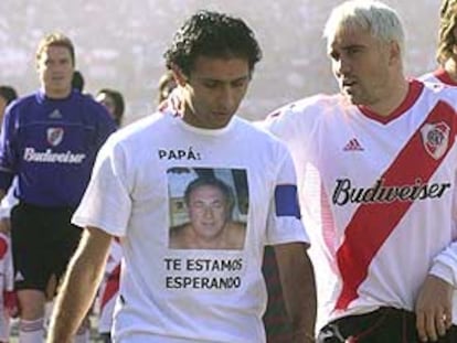 Astrada, con una camiseta alusiva al secuestro de su padre, junto a Coudet, el domingo 6, día de su retirada.