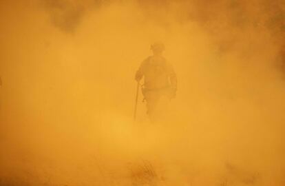 Un bombero camina entre el humo durante las labores de extinción de un incendio en Lakeport, California.