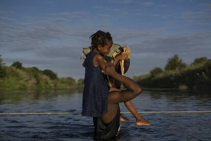 Un hombre haitiano con su hija a hombros cruza el Río Bravo entre Del Río (Texas) y Ciudad Acuña (México), este 22 de septiembre.