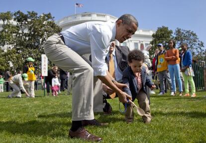 El presidente Barack Obama ayuda a un niño a llegar a la meta en la tradicional caza del huevo de Pascua.