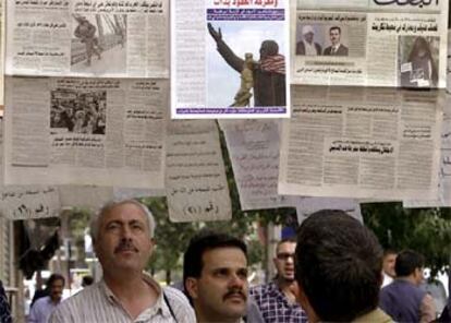 Ciudadanos sirios leen hoy las noticias de las acusaciones de Bush hoy en Damasco.