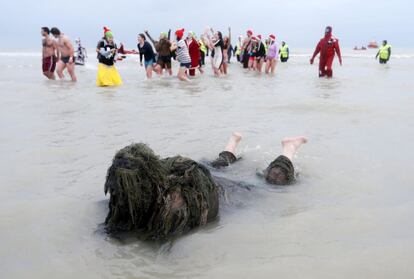 Participantes se mojan durante el tradicional baño de Año Nuevo celebrado en la ciudad belga de Ostende.