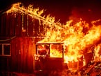 Flames shoot from a home as the Bear Fire burns through the Berry Creek area of Butte County, Calif., on Wednesday, Sept. 9, 2020. The blaze, part of the lightning-sparked North Complex, expanded at a critical rate of spread as winds buffeted the region. (AP Photo/Noah Berger)