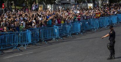 Aficionados del Real Madrid esperan la llegada del equipo madridista a la plaza de Cibeles.