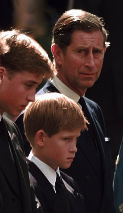 6 de septiembre de 1997. Los príncipes Enrique (c), Guillermo (i), son observados por su padre, el Príncipe Carlos de Inglaterra en el exterior de la Abadía de Westminster, donde se celebró el funeral de su madre, Diana.