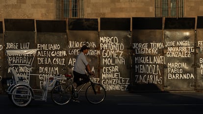 Un hombre pasa frente al Palacio Nacional antes de que llegue la protesta al Zócalo.