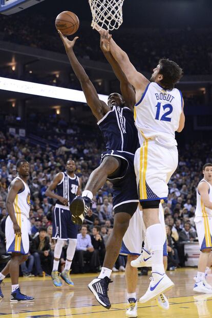 Ibaka, de los Thunder, intenta evitar el tapón de Bogut, de los Warriors.