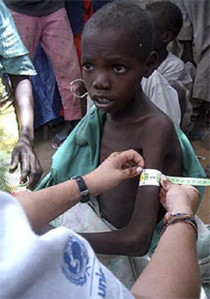 Una trabajadora de ACNUR atiende a un niño sudanés en Darfur.