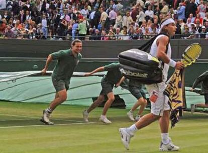 Rafael Nadal abandona la pista cuando el partido fue suspendido en el quinto <i>set.</i>