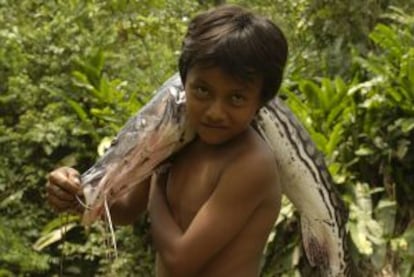 Un niño porta un pescado en Yasuní, cerca del río Napo.