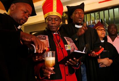 El líder de la Iglesia de Gabola, autoproclamado papa, Tsietsi Makiti (segundo a la izquierda), se prepara para bautizar a los recién llegados a esta comunidad durante un servicio en un bar en Orange Farm, al sur de Johannesburgo, el domingo 15 de abril de 2018. Esta nueva iglesia en Sudáfrica celebra el consumo de alcohol y ofrece servicios entusiastas y alimentados con alcohol en bares, para aquellos que han sido rechazados por otras parroquias porque beben.