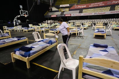 Una mujer desinfecta una cama habilitada para mayores de 65 años que serán alojados en el Palacio Peñarol en Montevideo, el 27 de marzo.