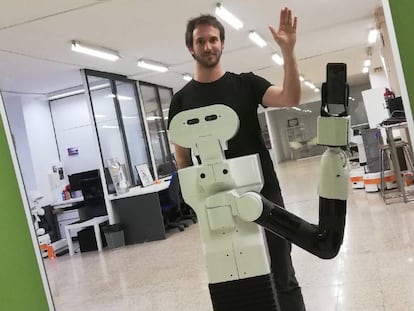 El doctor en ingeniería artificial Pablo Lanillos que posa junto a Tiago, un robot que es capaz de reconocerse frente a un espejo. 
