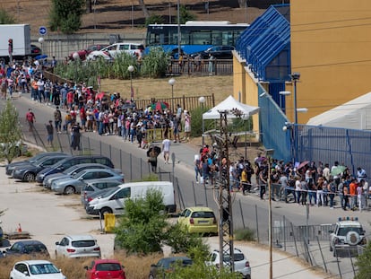 Cola de ciudadanos extranjeros frente a la comisaría de extranjería de Aluche, en Madrid, este jueves. / SANTI BURGOs