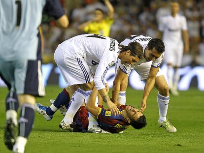 Sergio Ramos y Arbeloa levantan a Villa del césped mientras este se queja por una entrada del segundo.