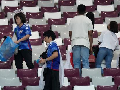 Aficionados japoneses recogen sus desperdicios en el estadio tras la victoria de su selección ante Alemania.
