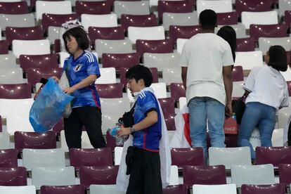 Aficionados japoneses recogen sus desperdicios en el estadio tras la victoria de su selección ante Alemania,  durante la Copa del Mundo organizada en Qatar, en noviembre de 2022.