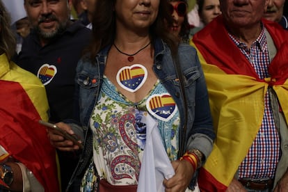 Pegatinas con las banderas de Europa, Cataluña y España son llevadas por una mujer.