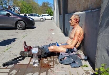 Un hombre herido, sentado en el exterior de un supermercado, tras un ataque ruso en Jersón, el miercoles. 