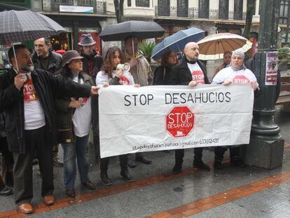 Miembros de la plataforma Stop Desahucios protestan frente a la BBK en Bilbao por los desalojos de pisos.