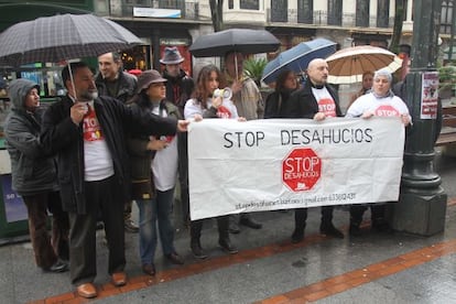 Miembros de la plataforma Stop Desahucios protestan frente a la BBK en Bilbao por los desalojos de pisos.